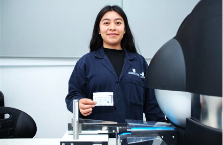 Jessica Quintana, asistente de Investigación en CIMMYT, sostiene un empaque de semillas de trigo para ser procesadas en el VideoMeter.